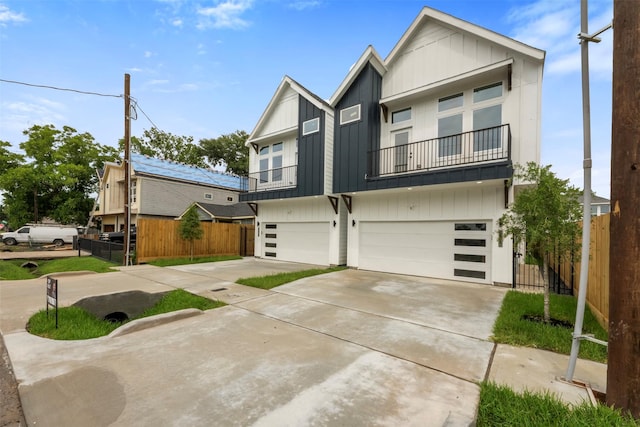 6815 Paris St, Houston, TX 77021 - view of front of house with board and batten siding, an attached garage, a balcony, and driveway