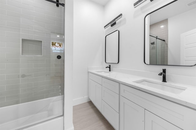 6815 Paris St, Houston, TX 77021 - bathroom with double vanity, wood finished floors, and bath / shower combo with glass door