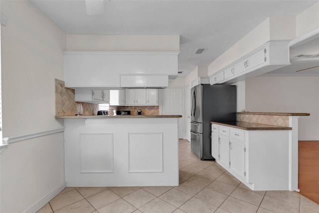 2010 Oceanview Dr, Seabrook, TX 77586 - kitchen with a peninsula, freestanding refrigerator, decorative backsplash, and white cabinets