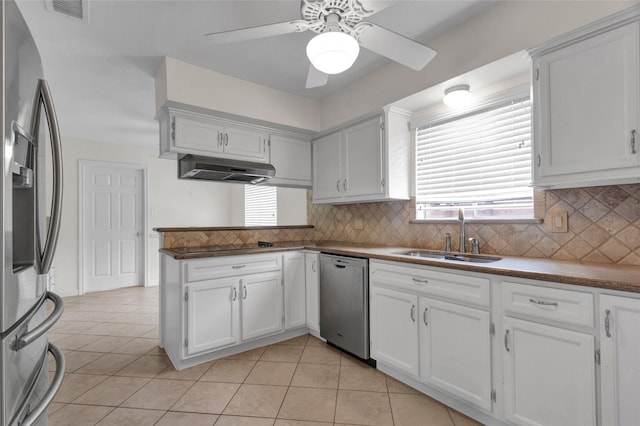 2010 Oceanview Dr, Seabrook, TX 77586 - kitchen with appliances with stainless steel finishes, under cabinet range hood, a ceiling fan, white cabinetry, and tasteful backsplash