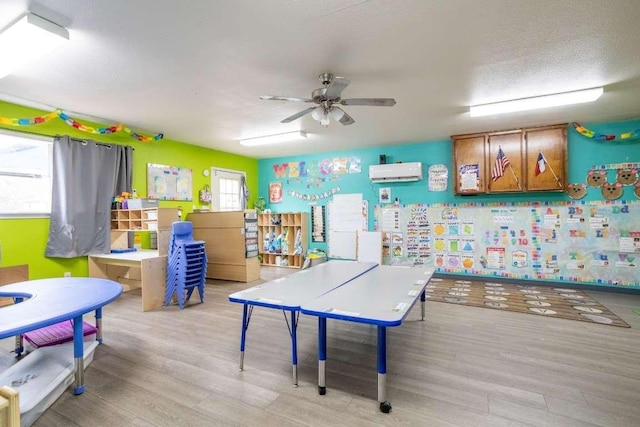 402 W Converse St, Weimar, TX 78962 - playroom featuring wood finished floors, a wall unit AC, and ceiling fan
