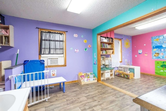 402 W Converse St, Weimar, TX 78962 - playroom featuring a textured ceiling and wood finished floors