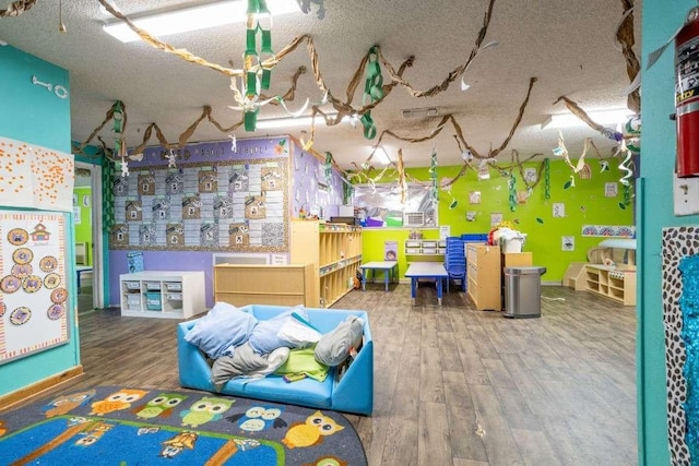 402 W Converse St, Weimar, TX 78962 - playroom featuring wood finished floors and a textured ceiling