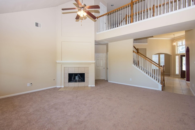 8603 E Windhaven Terrace Trl, Cypress, TX 77433 - unfurnished living room featuring high vaulted ceiling, arched walkways, stairs, carpet floors, and a ceiling fan