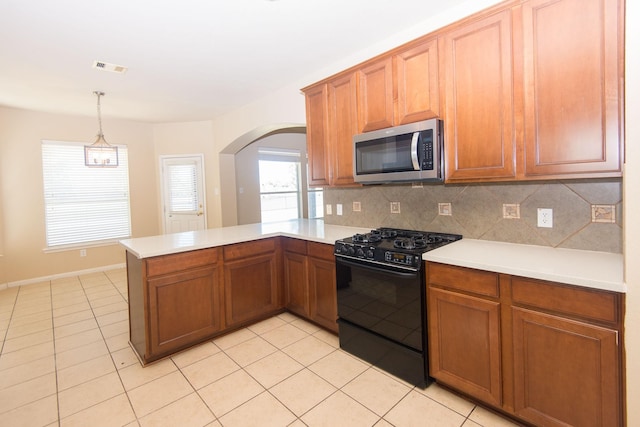 8603 E Windhaven Terrace Trl, Cypress, TX 77433 - kitchen featuring stainless steel microwave, gas stove, a peninsula, arched walkways, and light countertops