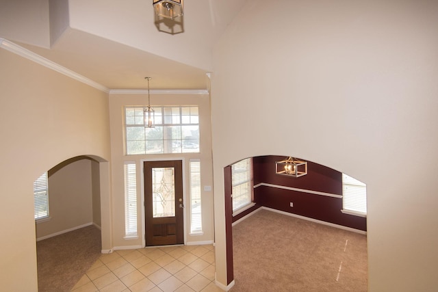 8603 E Windhaven Terrace Trl, Cypress, TX 77433 - carpeted entryway with arched walkways, a high ceiling, a chandelier, tile patterned flooring, and crown molding