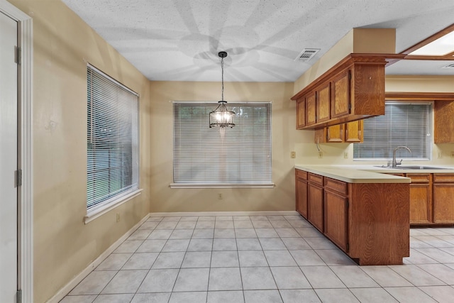 4327 Long Glen Dr, Houston, TX 77339 - kitchen featuring light countertops, brown cabinets, pendant lighting, light tile patterned flooring, and a chandelier