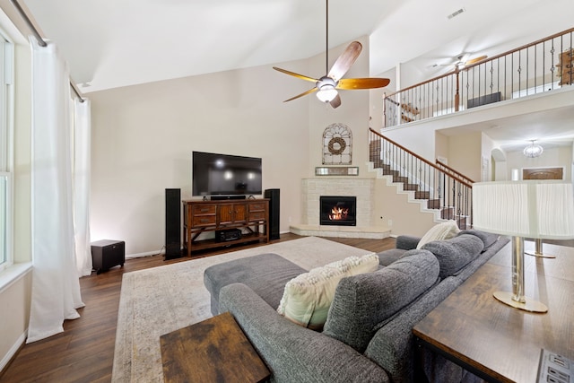 19610 Blushing Meadow Dr, Cypress, TX 77433 - living area featuring ceiling fan, dark wood-style flooring, a lit fireplace, high vaulted ceiling, and stairs
