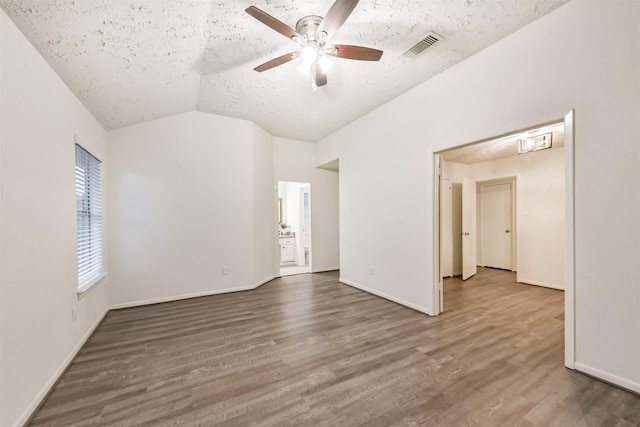 622 Magnolia Bend St, League City, TX 77573 - empty room with a textured ceiling, a ceiling fan, lofted ceiling, and wood finished floors