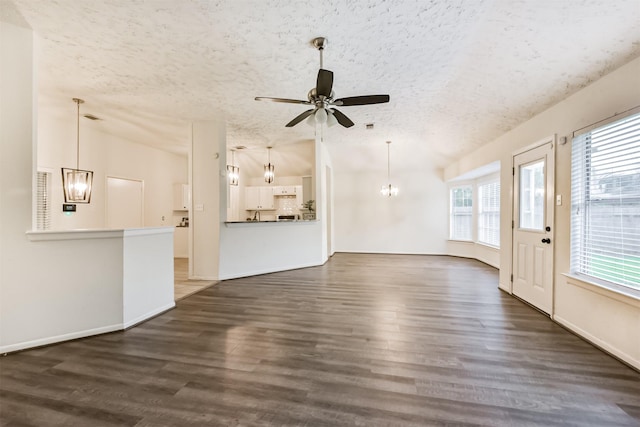 622 Magnolia Bend St, League City, TX 77573 - unfurnished living room featuring a textured ceiling, a ceiling fan, wood finished floors, and a chandelier