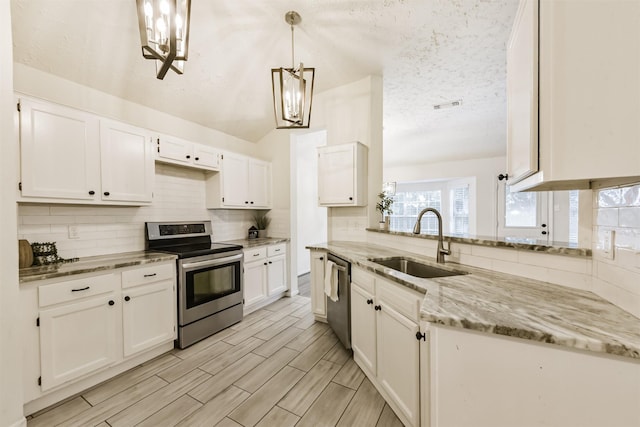 622 Magnolia Bend St, League City, TX 77573 - kitchen with appliances with stainless steel finishes, a chandelier, backsplash, white cabinets, and light stone countertops