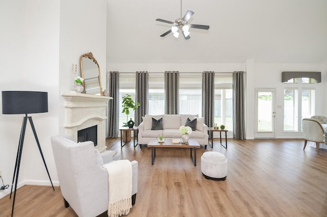 25619 Tower Side Ln, Katy, TX 77494 - living area featuring plenty of natural light, wood finished floors, ceiling fan, a fireplace, and high vaulted ceiling