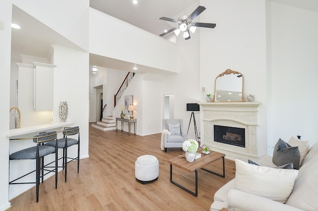 25619 Tower Side Ln, Katy, TX 77494 - living room with light wood-style flooring, a high ceiling, stairway, ceiling fan, and recessed lighting
