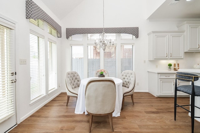 25619 Tower Side Ln, Katy, TX 77494 - dining area with a chandelier, healthy amount of natural light, vaulted ceiling, and light wood-style floors