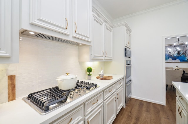 25619 Tower Side Ln, Katy, TX 77494 - kitchen with stainless steel gas cooktop, light countertops, white cabinets, crown molding, and dark wood-style flooring