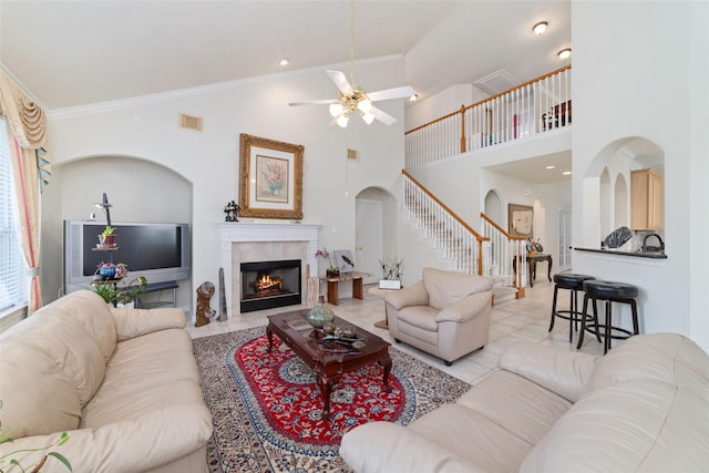 7311 Open Oak Way, Humble, TX 77346 - living area with arched walkways, stairway, ceiling fan, a fireplace, and ornamental molding