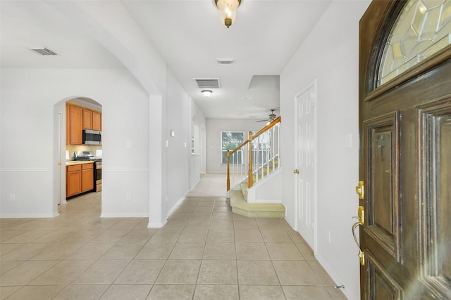 31 S Creekmist Pl, Conroe, TX 77385 - entrance foyer featuring arched walkways, light tile patterned floors, a ceiling fan, and stairway