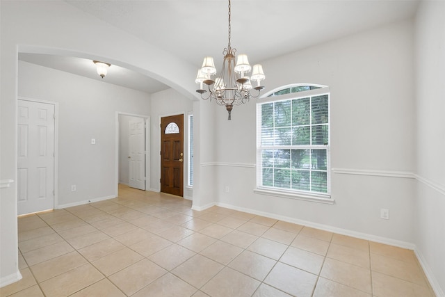 31 S Creekmist Pl, Conroe, TX 77385 - empty room featuring arched walkways, light tile patterned floors, and a chandelier
