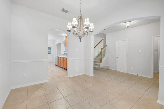 31 S Creekmist Pl, Conroe, TX 77385 - spare room with light tile patterned floors, a chandelier, stairway, and arched walkways