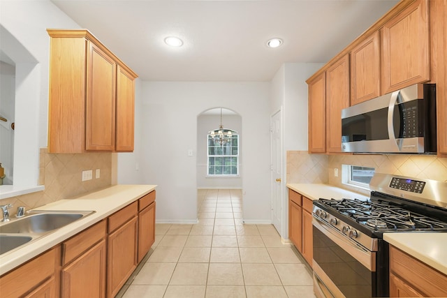 31 S Creekmist Pl, Conroe, TX 77385 - kitchen with stainless steel appliances, tasteful backsplash, light countertops, light tile patterned floors, and recessed lighting