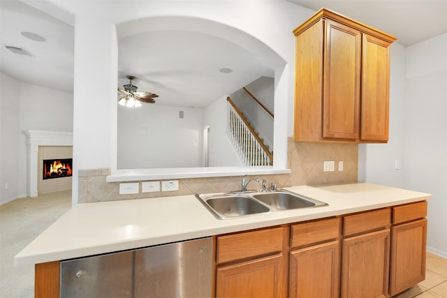 31 S Creekmist Pl, Conroe, TX 77385 - kitchen featuring a ceiling fan, backsplash, light countertops, stainless steel dishwasher, and a tile fireplace