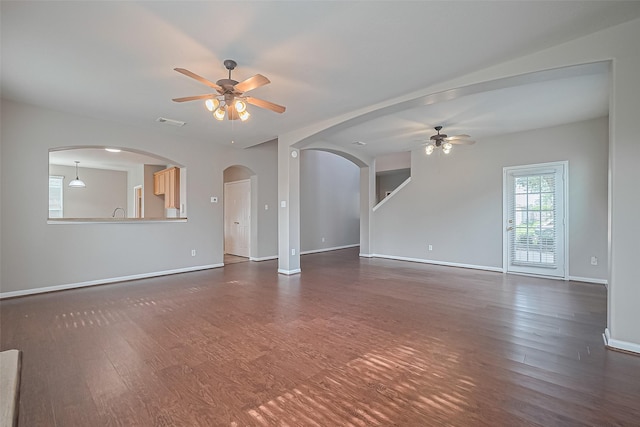 19819 Sternwood Manor Dr, Spring, TX 77379 - unfurnished living room with ceiling fan, arched walkways, and dark wood-style floors