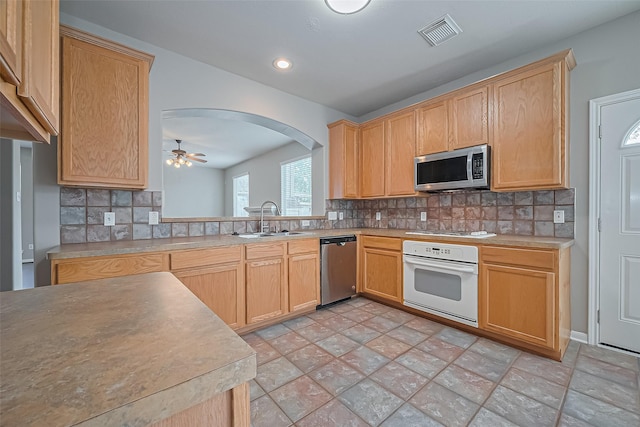 19819 Sternwood Manor Dr, Spring, TX 77379 - kitchen with stainless steel appliances, arched walkways, decorative backsplash, stone finish flooring, and recessed lighting