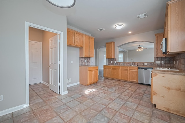 19819 Sternwood Manor Dr, Spring, TX 77379 - kitchen with stainless steel appliances, a ceiling fan, decorative backsplash, and arched walkways