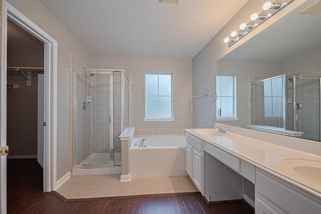 19819 Sternwood Manor Dr, Spring, TX 77379 - full bath featuring a stall shower, double vanity, a garden tub, a walk in closet, and wood finished floors