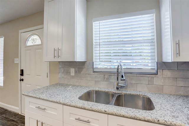 515 Main St, Pasadena, TX 77506 - kitchen with white cabinetry, decorative backsplash, light stone countertops, and plenty of natural light