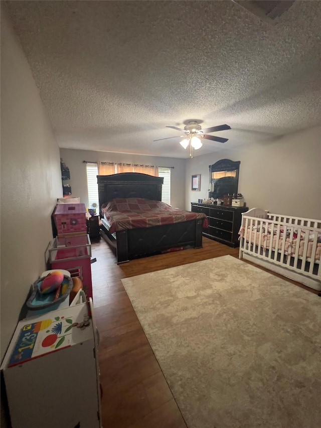 18703 Evergreen Falls Dr, Houston, TX 77084 - bedroom featuring a textured ceiling, multiple windows, dark wood-style floors, and ceiling fan