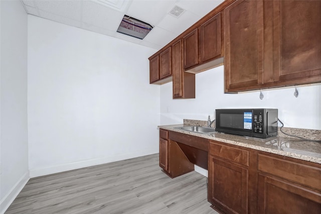 440 Cobia Dr Unit 1804, Katy, TX 77494 - kitchen with black microwave, light wood-style floors, light stone countertops, and a drop ceiling