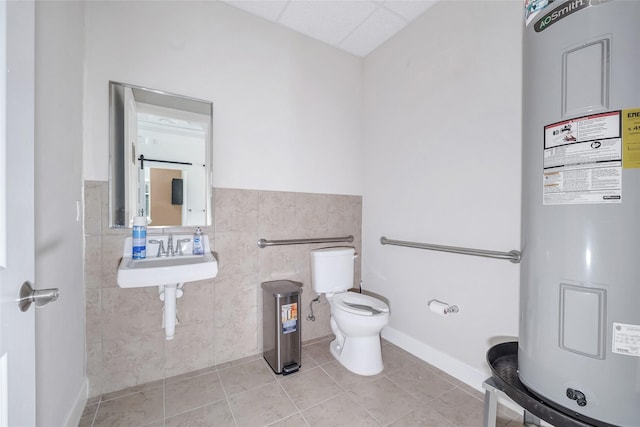 440 Cobia Dr Unit 1804, Katy, TX 77494 - half bathroom featuring water heater, tile patterned flooring, tile walls, and a wainscoted wall