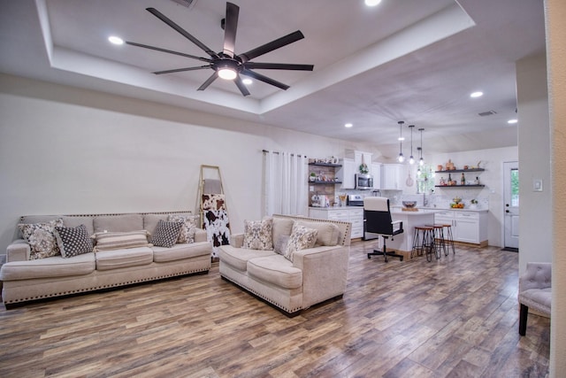 1226 Rd 5007, Cleveland, TX 77327 - living room featuring a tray ceiling, wood finished floors, recessed lighting, and a ceiling fan