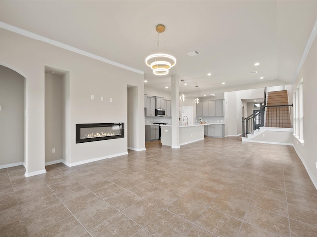 15754 Cairnwell Bend Dr, Humble, TX 77346 - unfurnished living room featuring crown molding, light tile patterned flooring, recessed lighting, a glass covered fireplace, and a chandelier