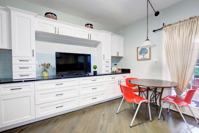 840 Threadneedle St E Unit 208, Houston, TX 77079 - kitchen with wood finished floors, white cabinets, tasteful backsplash, and pendant lighting
