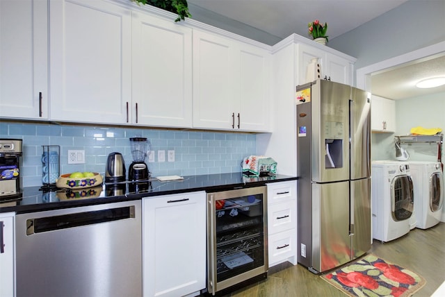840 Threadneedle St E Unit 208, Houston, TX 77079 - kitchen with stainless steel appliances, washing machine and clothes dryer, wine cooler, wood finished floors, and decorative backsplash