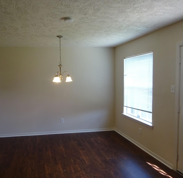 21606 Haylee Way, Humble, TX 77338 - unfurnished room with a chandelier, dark wood-type flooring, a textured ceiling, and a smoke detector