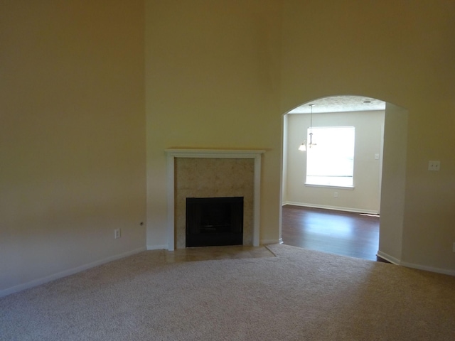 21606 Haylee Way, Humble, TX 77338 - unfurnished living room featuring carpet flooring, arched walkways, and a fireplace
