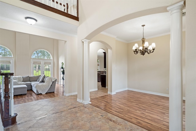 15590 Crown Oaks Dr, Montgomery, TX 77316 - foyer with arched walkways, crown molding, inlaid floor details, wood finished floors, and a chandelier
