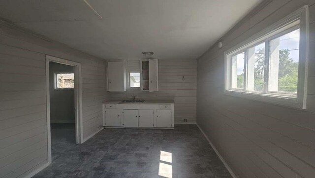 6909 Kittridge St, Houston, TX 77028 - kitchen featuring wood walls, white cabinetry, and light countertops