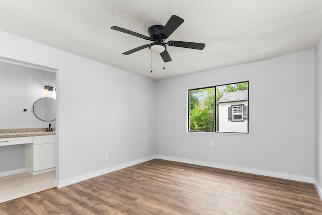 16234 Bowridge Ln, Houston, TX 77053 - unfurnished bedroom with wood finished floors, a textured ceiling, ceiling fan, and ensuite bath