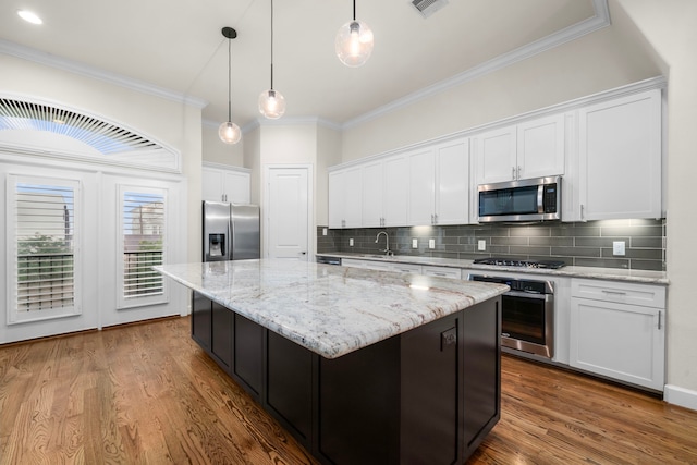 4314 Gibson St Unit B, Houston, TX 77007 - kitchen featuring stainless steel appliances, a center island, crown molding, white cabinetry, and tasteful backsplash