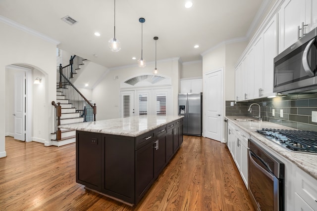 4314 Gibson St Unit B, Houston, TX 77007 - kitchen with stainless steel appliances, a kitchen island, white cabinets, ornamental molding, and backsplash