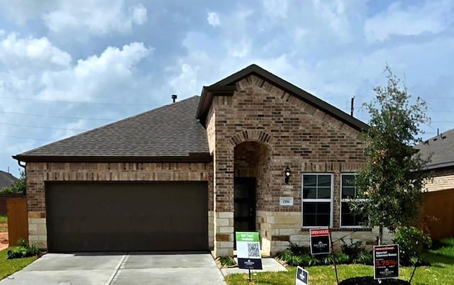 2556 Newport Breeze Dr, Katy, TX 77493 - view of front of house featuring a garage, a shingled roof, concrete driveway, and stone siding