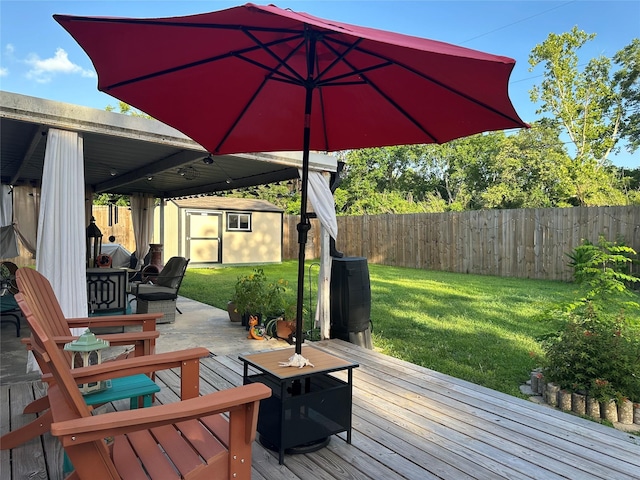 1205 Carmie St, Alvin, TX 77511 - deck featuring a fenced backyard, outdoor dining area, and a storage unit