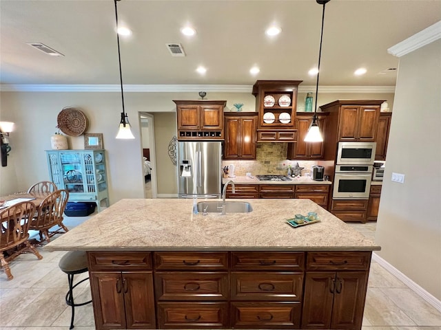 1464 S Bluebonnet Ln, Angleton, TX 77515 - kitchen with stainless steel appliances, tasteful backsplash, a kitchen island with sink, light stone countertops, and pendant lighting