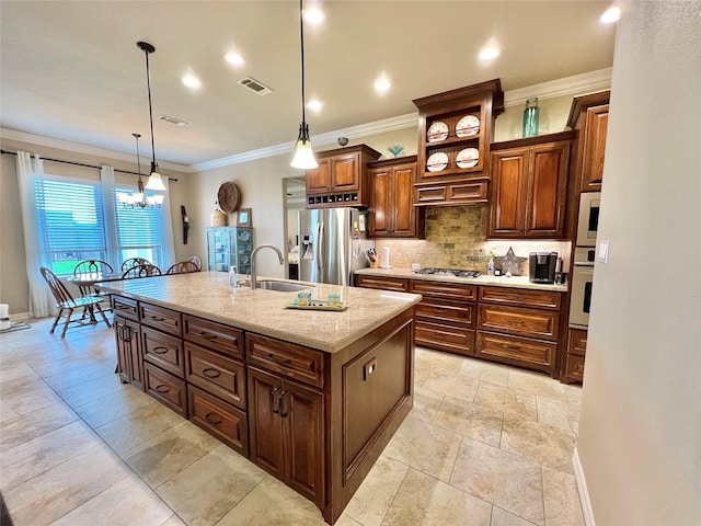 1464 S Bluebonnet Ln, Angleton, TX 77515 - kitchen with stainless steel appliances, a center island with sink, backsplash, crown molding, and hanging light fixtures