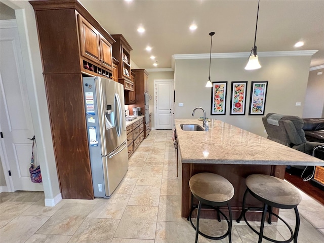 1464 S Bluebonnet Ln, Angleton, TX 77515 - kitchen with stainless steel fridge with ice dispenser, crown molding, a kitchen island with sink, a breakfast bar area, and recessed lighting