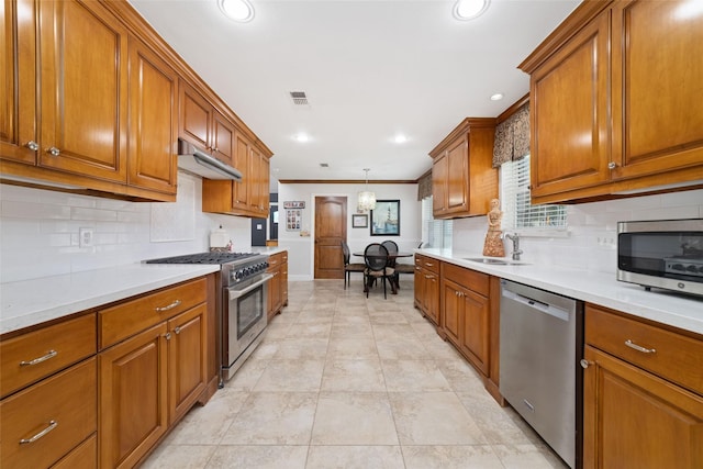 13302 Holston Hills Dr, Houston, TX 77069 - kitchen with appliances with stainless steel finishes, brown cabinetry, under cabinet range hood, tasteful backsplash, and light countertops